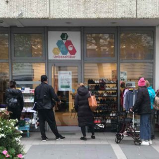 Die UnbezahlBar von außen mit Menschen, die ins Schaufenster gucken.